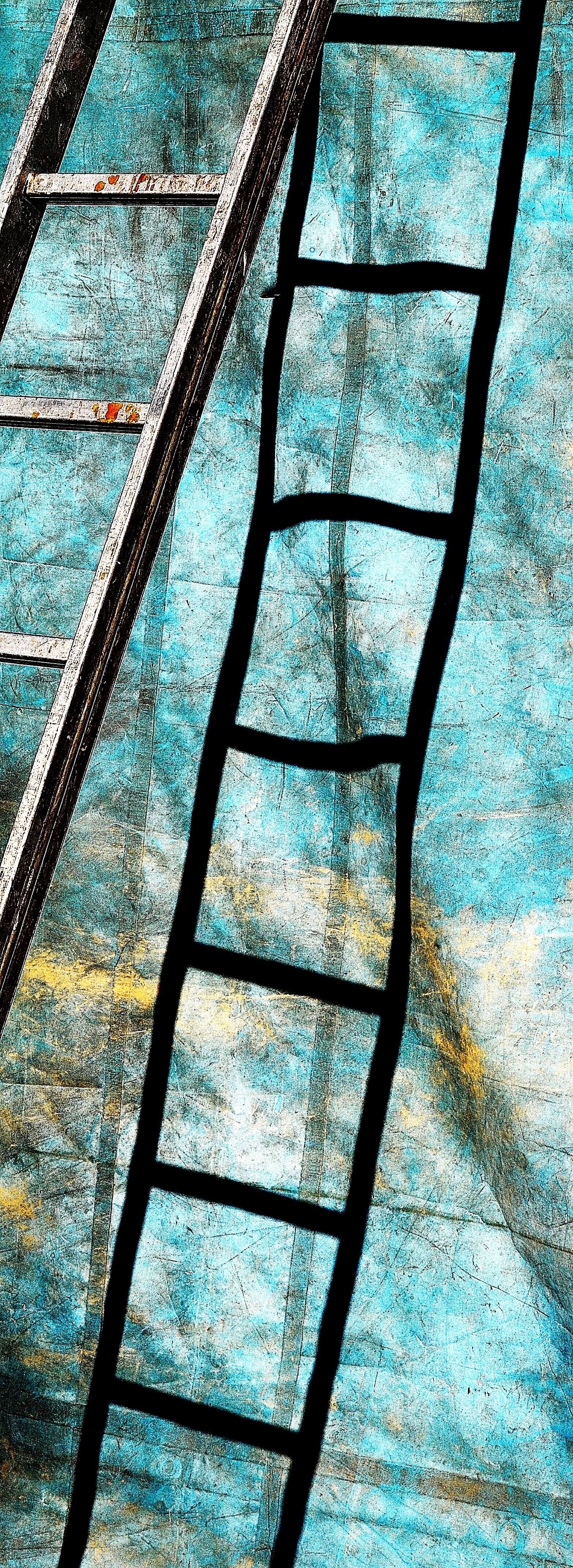 Abstrakte Ansicht von zwei Leitern, einer echten und einer schwarzen Zeichnung, die schräg über eine strukturierte türkisfarbene Fläche gelegt sind.